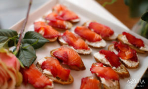 A hrs d'oeurves platter of pacific northwest salmon beet red lox with caper cream cheese on house made rye bread crostini. Served at a winery wedding.