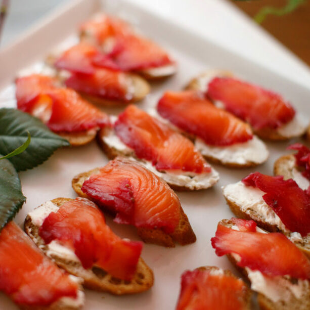 A hrs d'oeurves platter of pacific northwest salmon beet red lox with caper cream cheese on house made rye bread crostini. Served at a winery wedding.